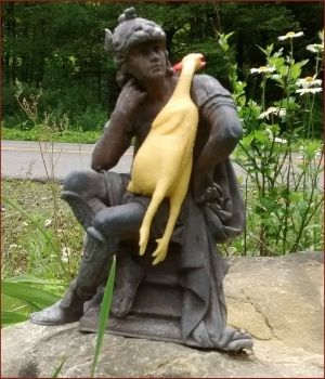 chicken resting on statue